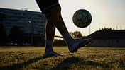 Legs,Of,Young,Man,Kicking,Ball,At,Green,Field.,Male