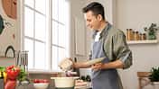 Young,Man,Cooking,Food,In,Kitchen