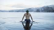 Man swimming in frozen lake