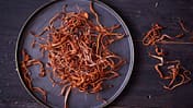 Vitalpilz Cordyceps auf einem schwarzen Teller