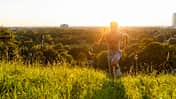 Mann rennt bei Sonnenuntergang über eine Wiese