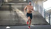 Mann joggt oberkörperfrei eine Treppe runter