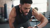 Ein Mann in Sportkleidung schaut auf seine Fitnessuhr