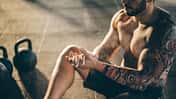 Ein oberkörperfreier Mann mit einem Tattoo am Arm