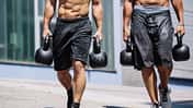 Männer machen den Farmers Walk mit Kettlebells