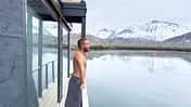 Man relaxing on sauna dock and contemplating the fjord view