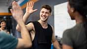Fitness trainer encouraging class with high fives