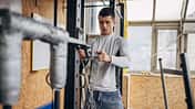 Ein junger Mann bereitet im Fitnessstudio Ketten für sein Training vor Ein junger Mann bereitet im Fitnessstudio Ketten für sein Training vor