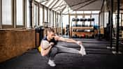 Junger Mann führt in einem Fitnessstudio eine single-leg-Übung mit einem Kettleball aus