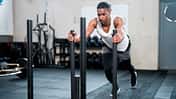 Sportler schiebt einen gewichteten Schlitten in einem Fitnessstudio