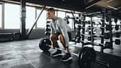 Ein Mann führt Deadlifts aus mit einer Langhantel im Gym
