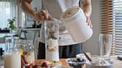 Ein junger Mann bereitet sich im Mixer einen Proteinshake zu