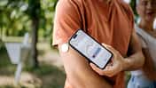Ein Mann überprüft seinen Blutzucker mit einem Smartphone