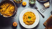 Ein Küchentisch mit Spaghetti und Kürbis