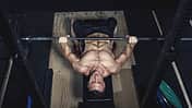 Physical athlete doing barbell bench presses