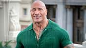 Dwayne Johnson lächelt im grünen Oberteil in die Kamera